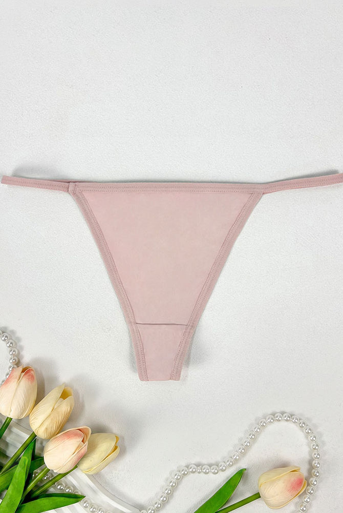 Low-rise thong panties in blush pink with seamless soft stretch fabric.