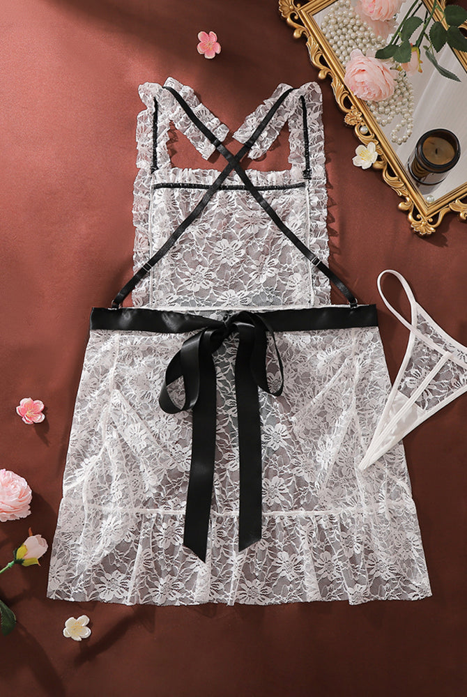 White lace mini chemise dress with cross-back straps and black bow at waist, matching thong panty