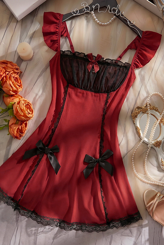 Wine red satin babydoll mini dress with black mesh bodice and bow accents, lace hem
