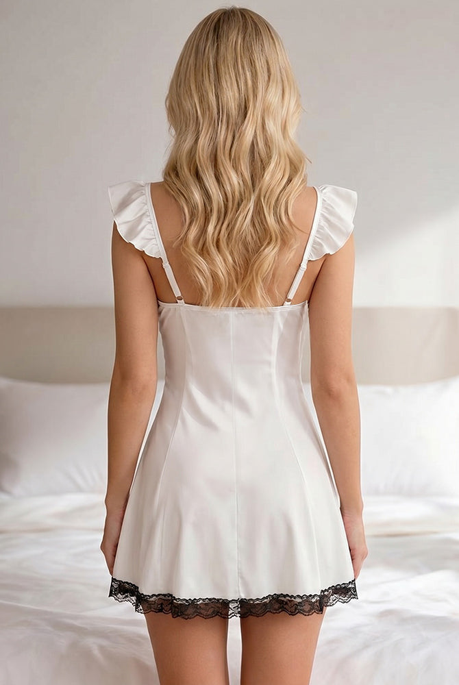 White babydoll mini dress with ruffle shoulder details and lace hem trim, back view