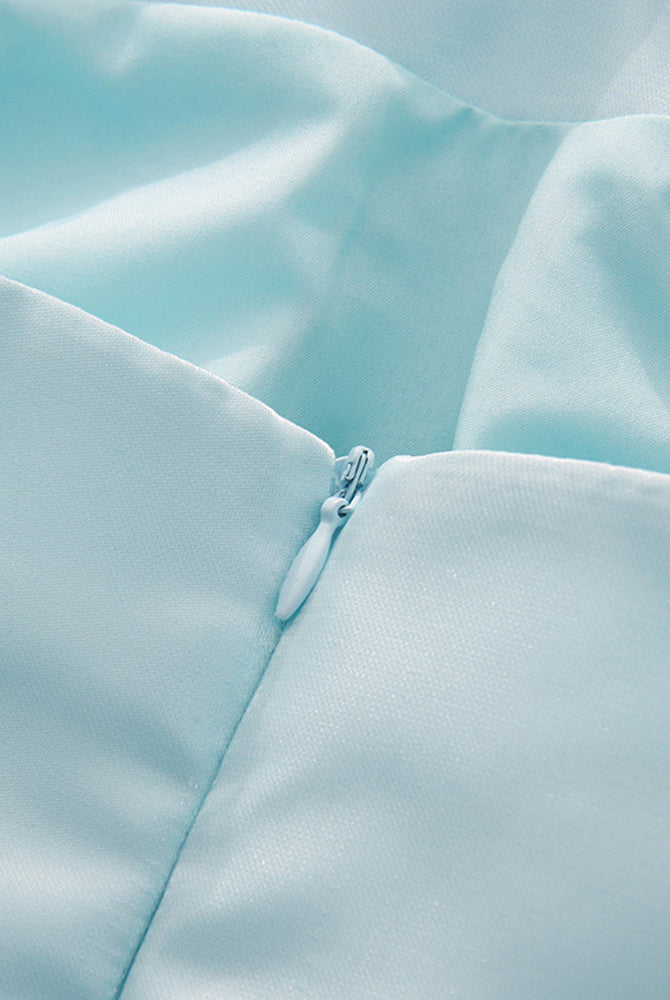 Close-up of sky blue fabric corset seam with a small decorative button.