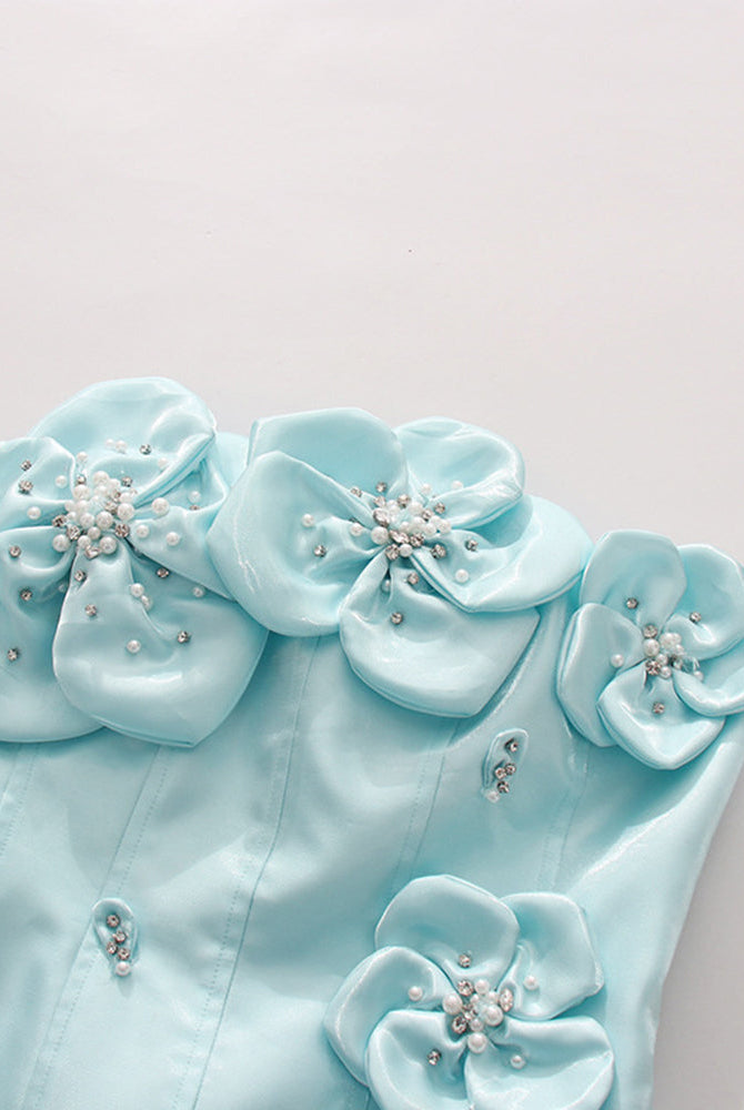 Close-up of sky blue corset with 3D floral rosettes, faux pearls, and bead clusters.