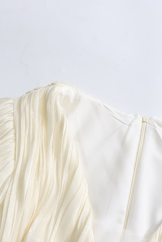 Champagne puff sleeve with pleated, layered ruffles at the cuff