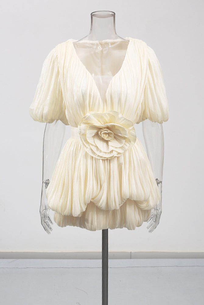 Champagne mini dress on mannequin with deep V, puff sleeves, and floral waist applique