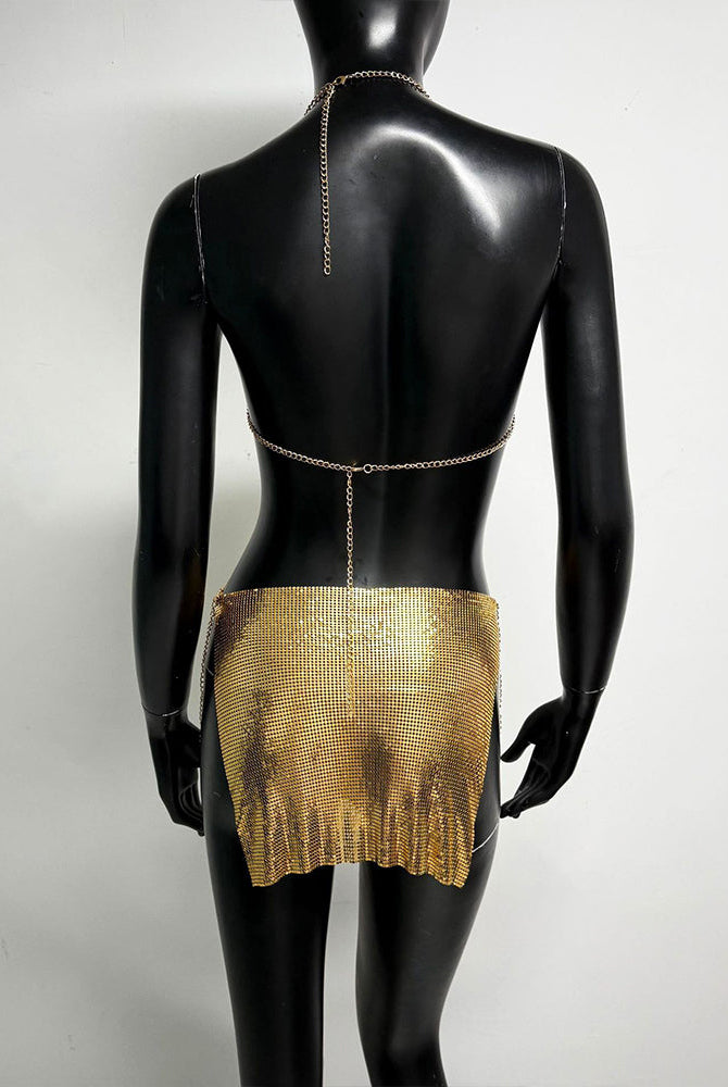 Gold metallic chain bra top and mini skirt set on mannequin, open back with chains