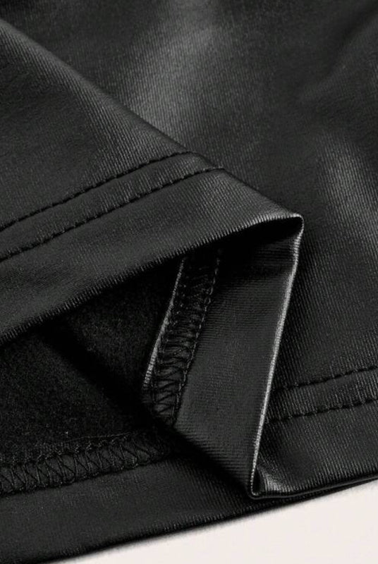 Black metallic crop top close-up of ruched seam and stitched hem edge.