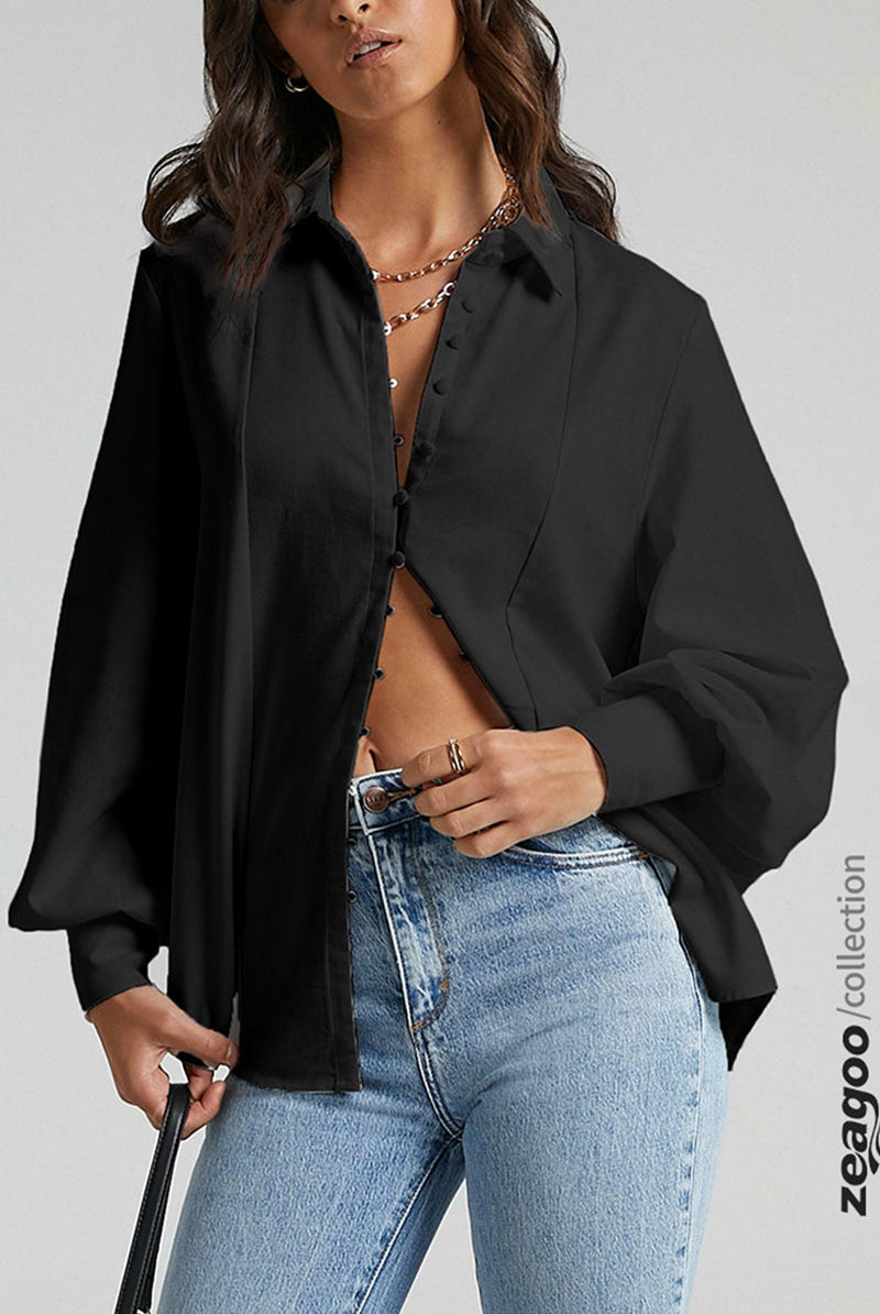 Black long sleeve blouse with button details, paired with blue jeans. Casual and stylish outfit.