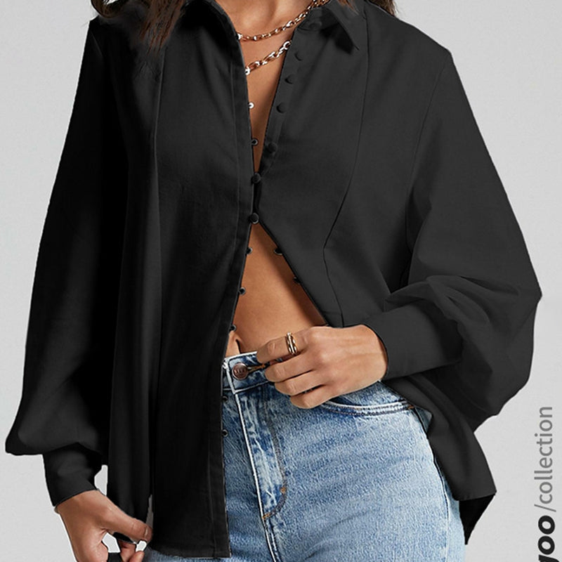 Black long sleeve blouse with button details, paired with blue jeans. Casual and stylish outfit.