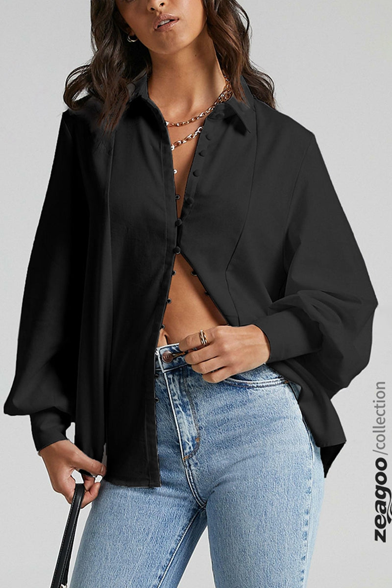 Black long sleeve blouse with button details, paired with blue jeans. Casual and stylish outfit.