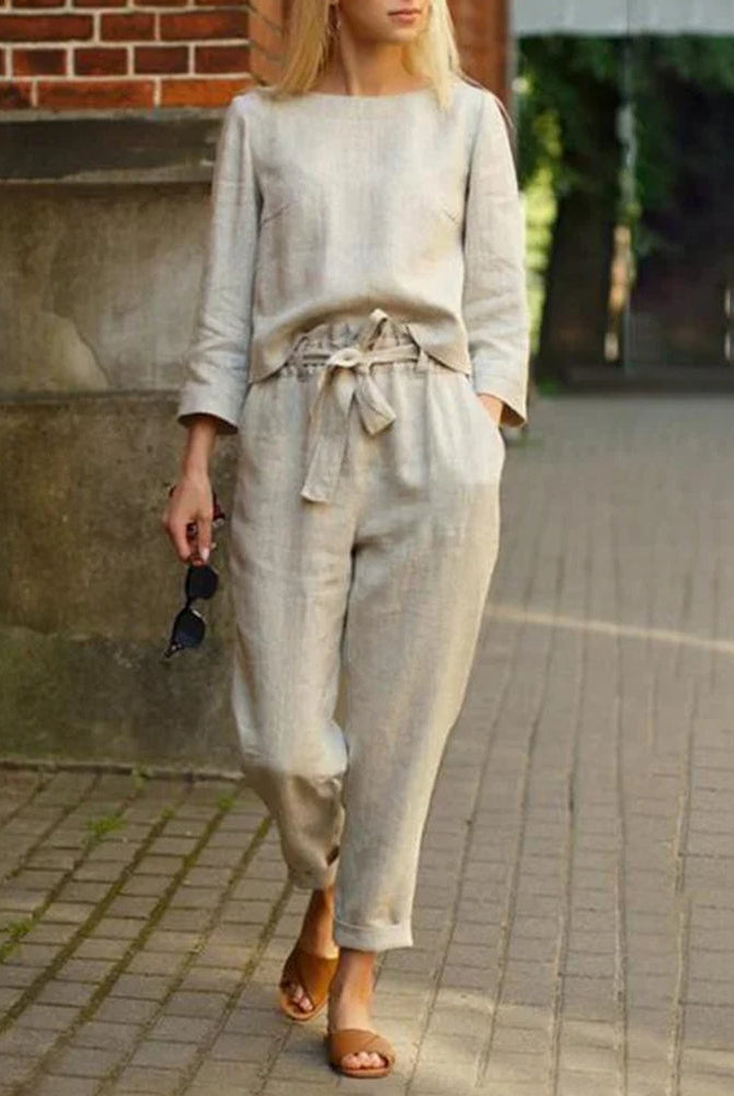Beige two-piece pants set, perfect for vacation and leisure. Features a tie belt and long sleeves.