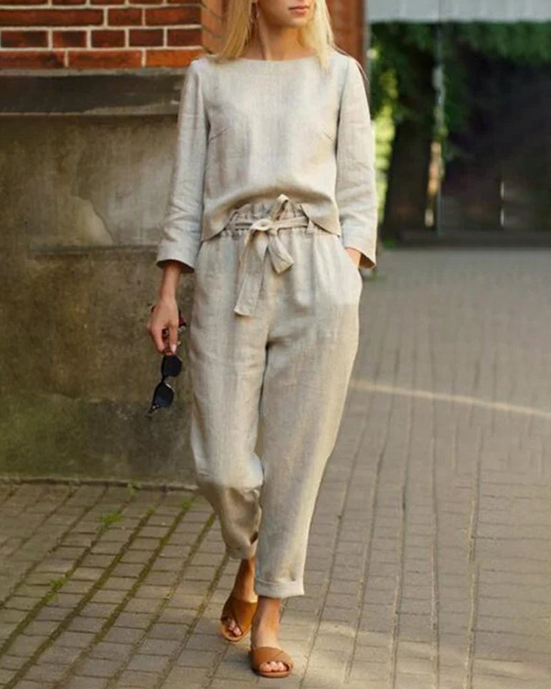 Beige two-piece pants set, perfect for vacation and leisure. Features a tie belt and long sleeves.