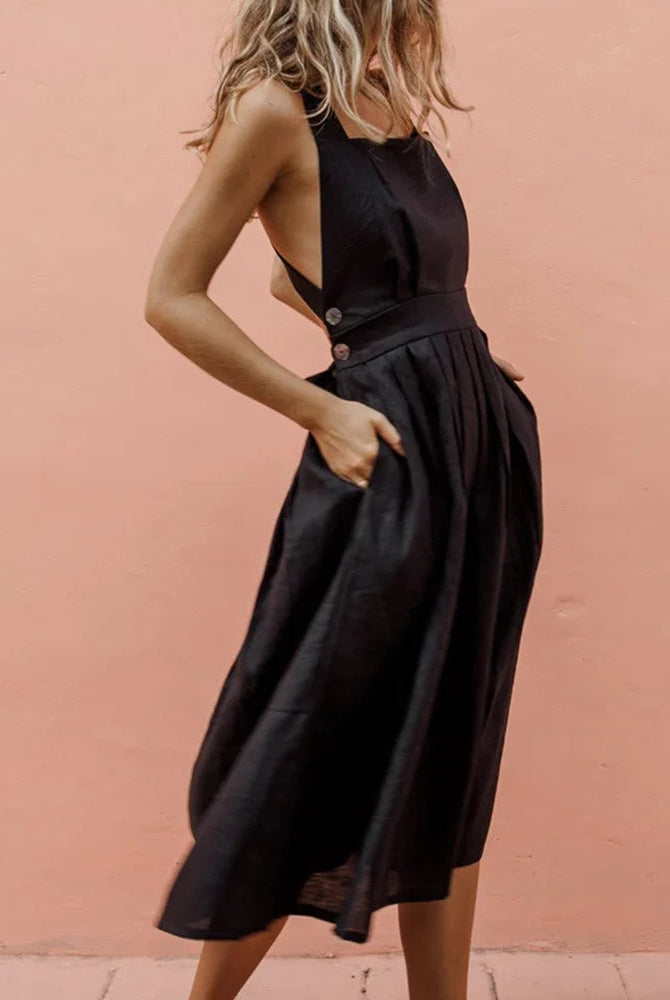 Black strap button waist pleated dress for vacation, featuring halter neckline and pleated skirt