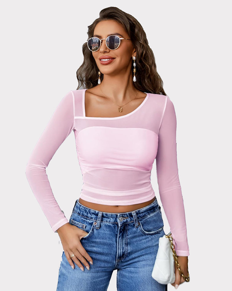 Pink mesh asymmetrical crop top with long sleeves, unique neckline, and denim jeans.