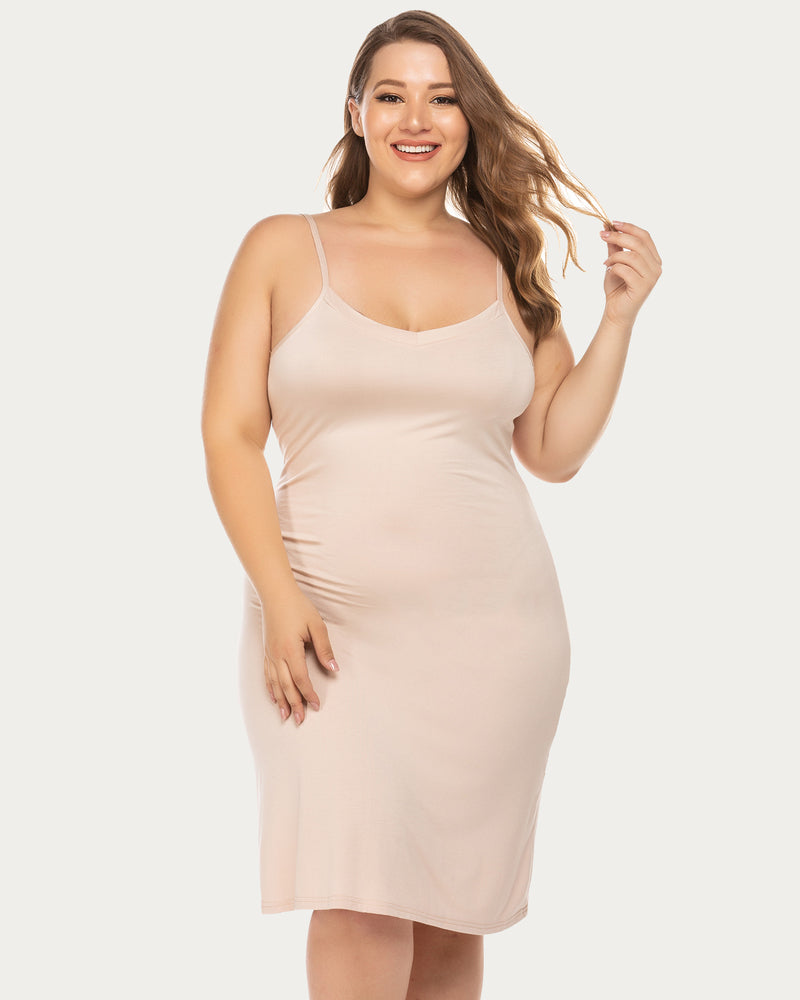 Curvy model in fitted light pink plus-size chemise nightgown with adjustable straps.