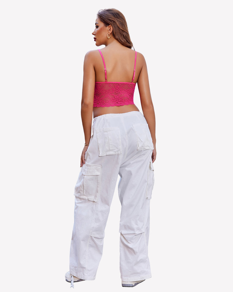 Back view of a woman in pink lace bralette and white cargo pants. Elegant lingerie set.