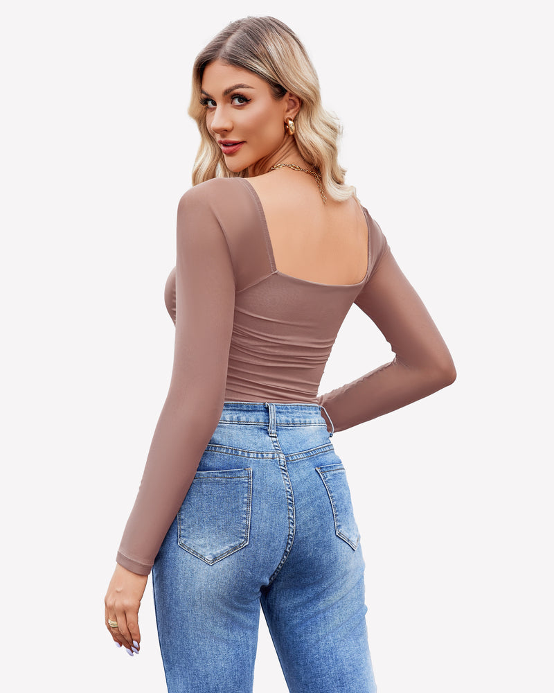 Taupe square neck mesh bodysuit with ruched detail & long sleeves, worn with jeans and gold jewelry.