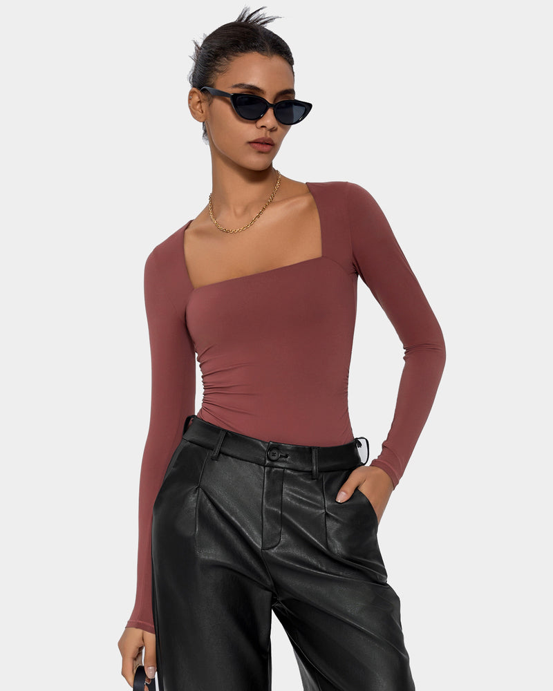Terracotta square neck bodysuit, long sleeve, elegant shapewear. Paired with black leather pants.