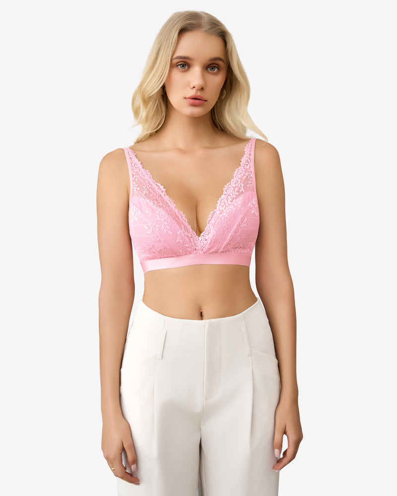 Pink lace wireless bralette with adjustable straps and floral lace, paired with white pants.
