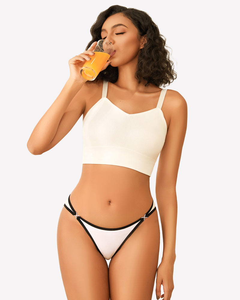 White low-rise thong panty with black trim and rhinestone accents, woman drinking juice