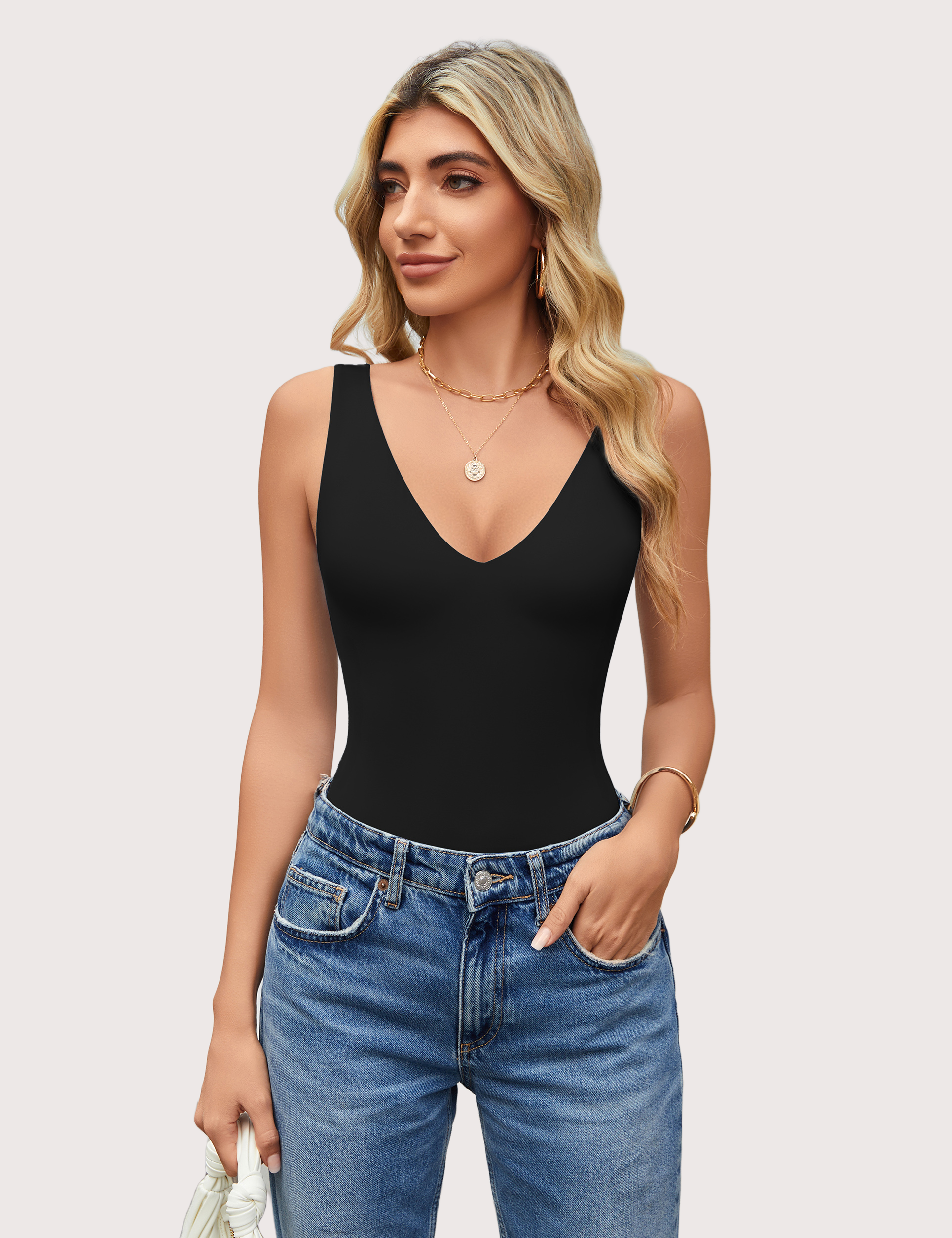 Black double-lined bodysuit leotard with plunging V-neckline and open back, paired with jeans.