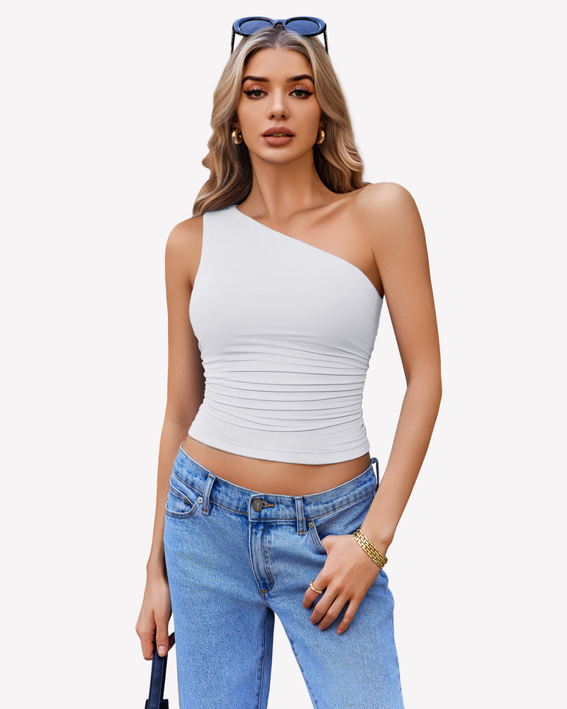 White one-shoulder crop top with ruched detail and blue jeans. Stylish and casual.