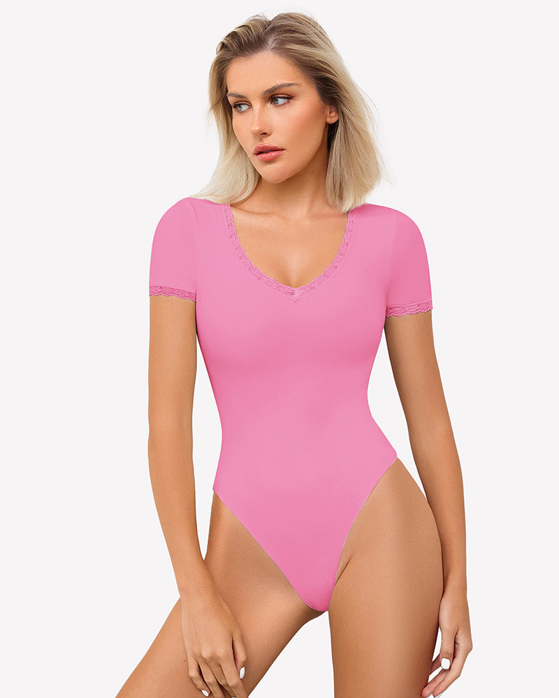 Pink V-neck bodysuit with lace trim, offering light smoothing and a flattering fit.