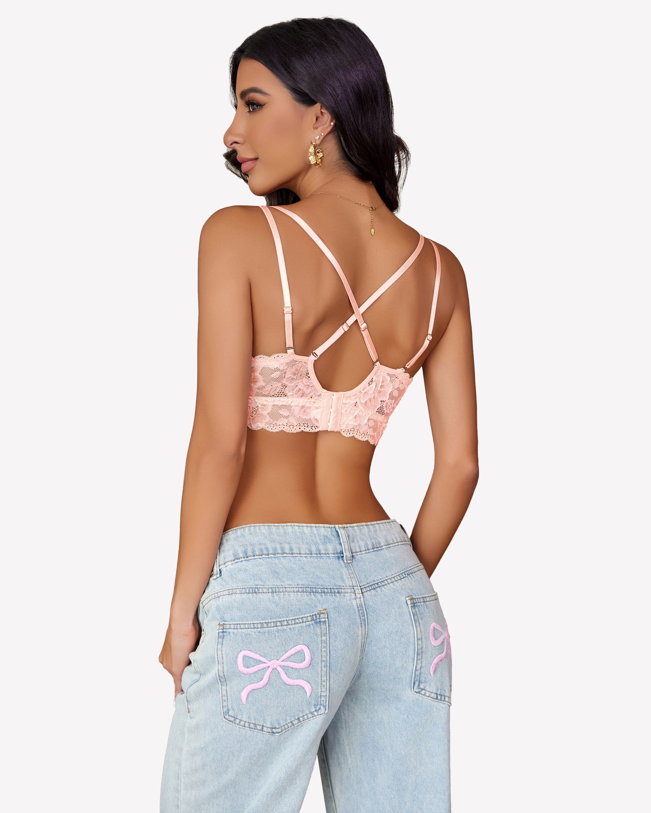 Pink floral lace bralette with cross-back design and denim jeans. Sexy lingerie for women.