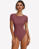 Purple-red short-sleeve snap bodysuit, fitted one-piece leotard top.