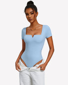 Light blue square-neck short-sleeve bodysuit on model with open-back hip strap detail