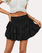 Maroon ruffle mini skirt with smocked waistband and layered tiers, worn with a black top.