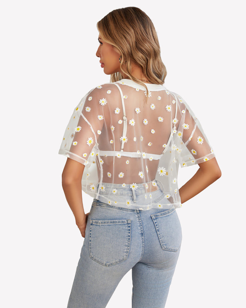 White daisy mesh crop top paired with light blue jeans, trendy see-through shirt.