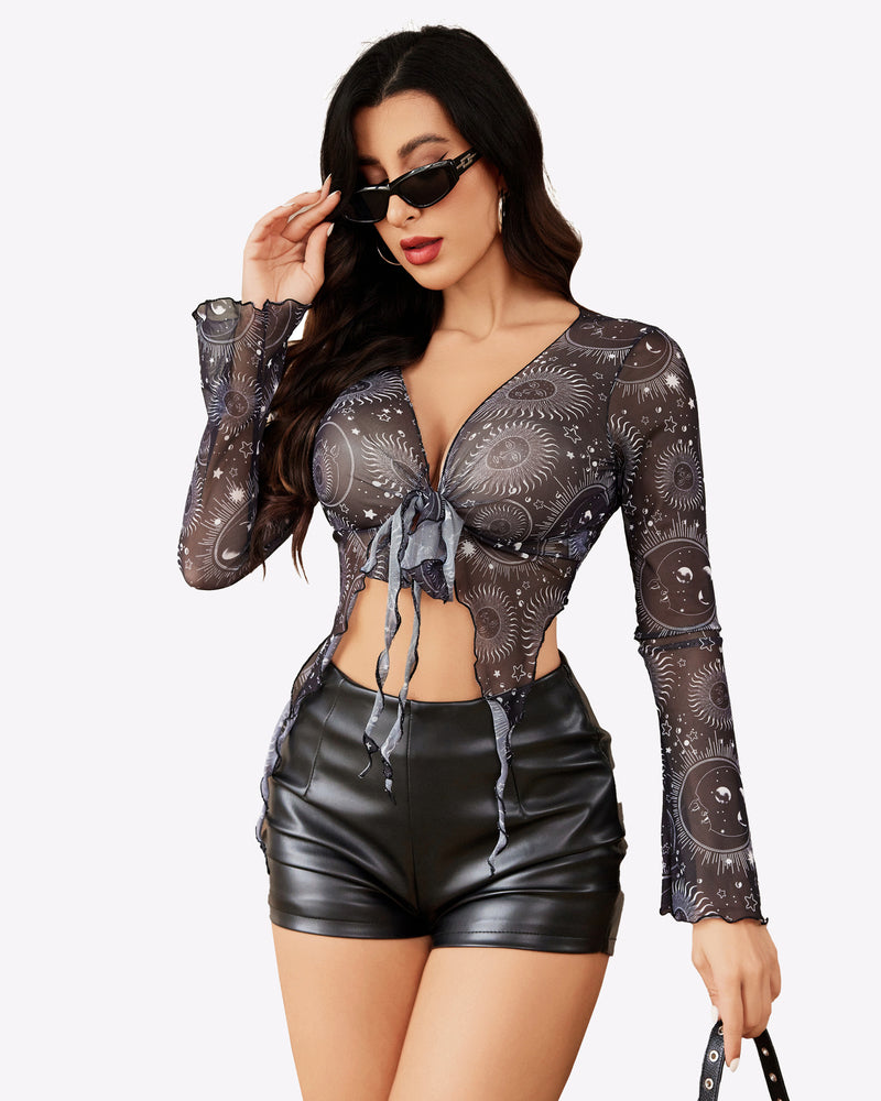 Mesh crop top, Y2K style, with celestial print and tie front. Black shorts. Long sleeves.