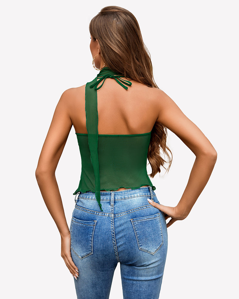 Green mesh Y2K crop top with halter neck, tie detail, paired with blue jeans, Y2K fashion.