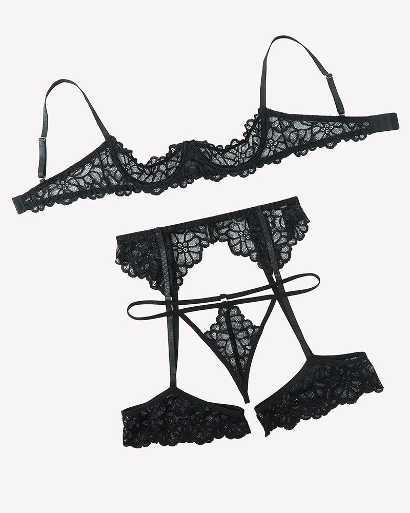Black lace lingerie set flat lay: lace bra, garter belt, thong, garter tops