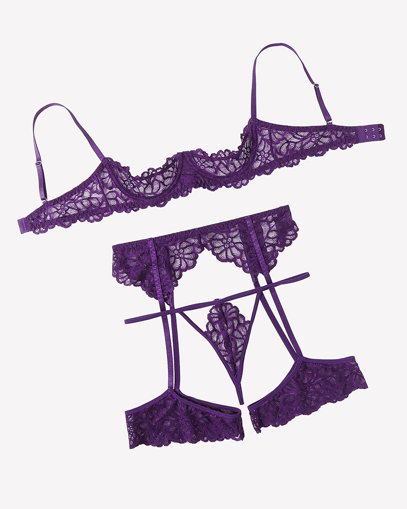 Purple lace lingerie set laid out: bra, thong, and garter belt with straps