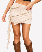 Champagne asymmetrical ruffle tie mini skirt with layered frill panels and draped ties
