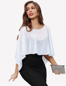 Sheer chiffon capelet wrap with batwing sleeves, loose drape over dark fitted dress