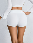 High-rise ruched mini shorts in white with elastic waistband, back view