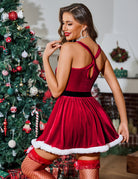 Back view of red velvet dress with crossed straps and white fur-trimmed hem