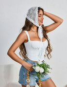 White floral lace triangle head scarf with long tie, draped over hair.