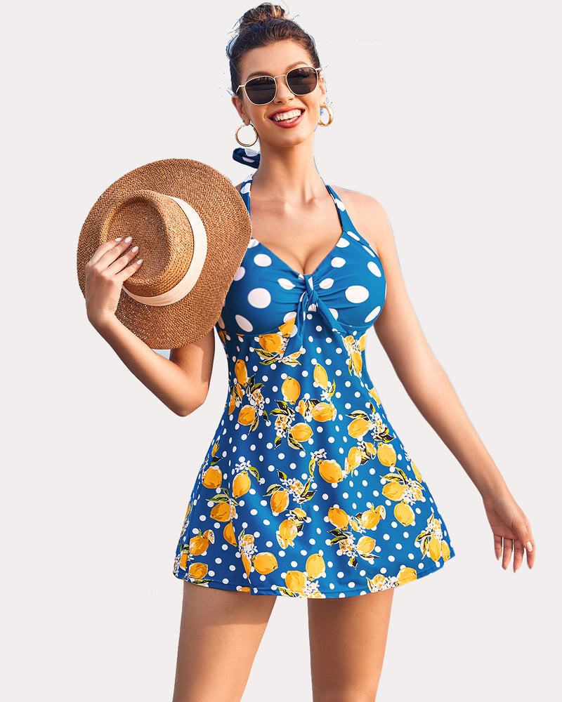Lemon print halter tankini swimsuit with boyshorts. Blue polka dot pattern, smiling woman.