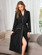 Full-length knit bathrobe, black with white trim and a tied waist belt