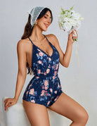 Navy blue floral romper with spaghetti straps, lace trim, and a gathered waist