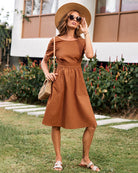 Brown midi dress with short sleeves, pockets, and a flattering fit, perfect for a stylish look.