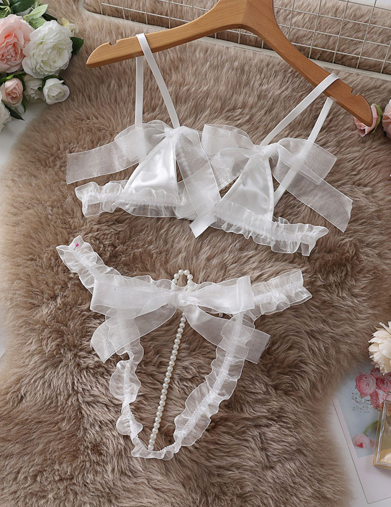 White lace lingerie set pieces: bra top, ruffled panties, and garters with pearl trim