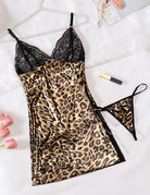 Leopard print satin chemise with black lace trim and pearl chain accessory, laid flat