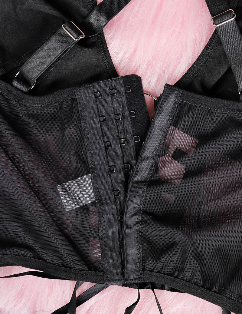 Close-up of black bra back with adjustable hook-and-eye band and sheer mesh panels