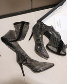 Black rhinestone fishnet over-the-knee stiletto boots, pair on display