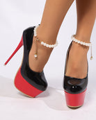 Black patent platform ultra high heel pumps with red base and pearl anklet chain