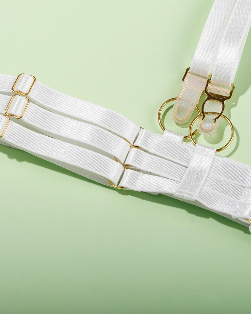 White lingerie set with adjustable straps and gold hardware, delicate and seductive.